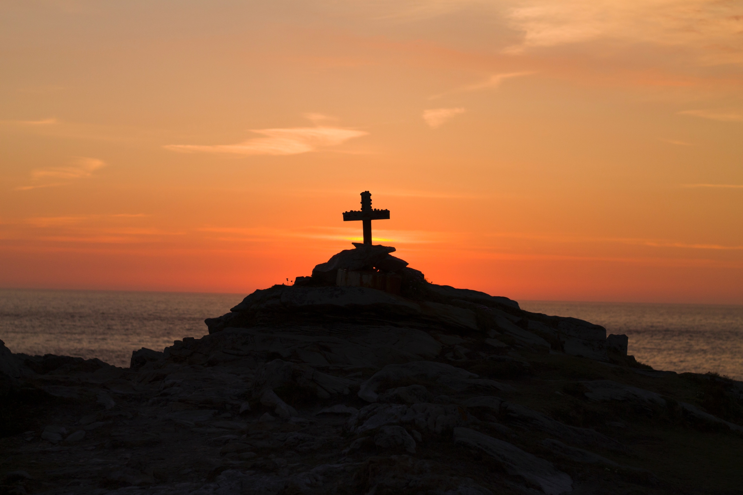 cross silhouette on mountain during golden hour